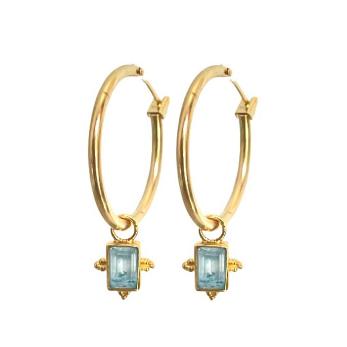Aros bañadas en oro con colgante en topacio azul por Bechi Ulivi Jewels.
Gold-plated hoops with blue topaz pendants made by Bechi Ulivi Jewels.
